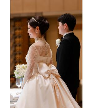 お召しいただいたウェディングドレスは、<br>プリンセスラインに長袖のハイネックを<br>合わせた、ロイヤルな一着。<br><br><br>クラシカルで気品溢れる佇まいが印象的で<br>花嫁さまの美しさをより一層引き立てていました。<br><br>バックスタイルには、リボンをあしらい<br>後ろ姿にはさりげない可愛らしさも♡<br>