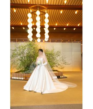 シンプルなデザインのドレスだからこそ<br>敢えてアクセサリーも一粒パールの物を。<br><br>ヘッドドレスは、シンプルボンネ、<br>グローブは、ロングの物をを付け、<br>よりクラシカルな雰囲気に。<br><br>透け感の少ないシンプルな<br>パイピングロングヴェールが<br>品格溢れる花嫁姿にしてくれます。<br><br><br><br>▫披露宴<br>